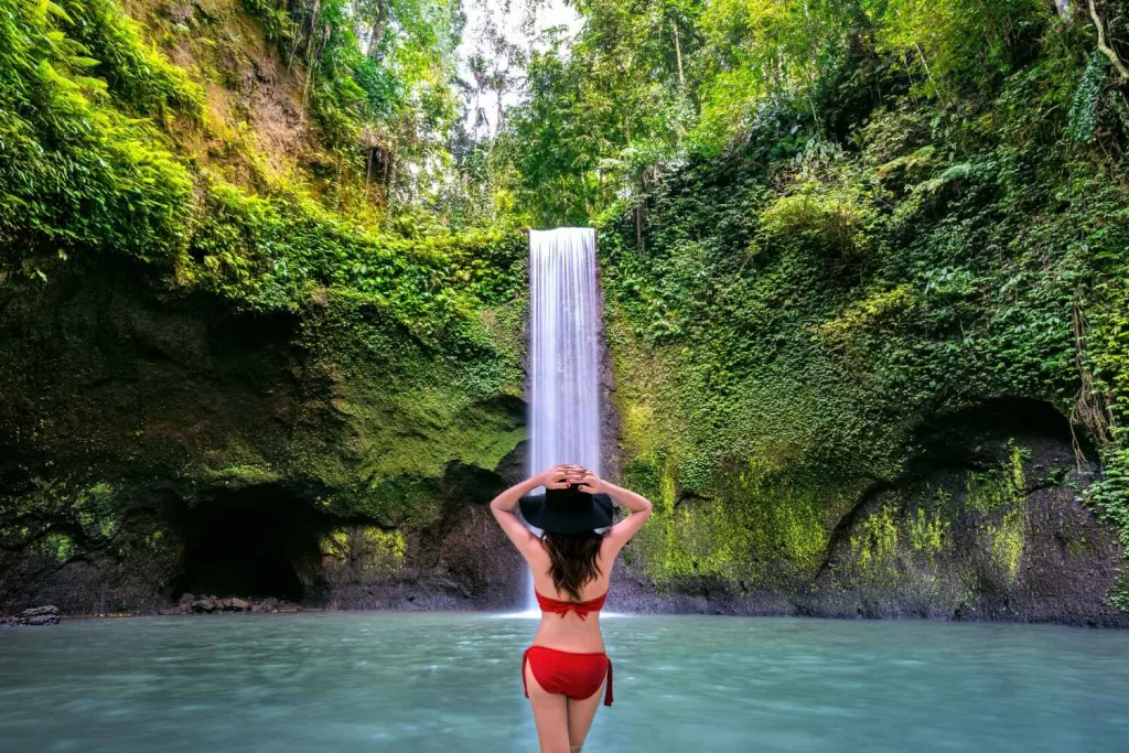 A woman standing in Tibumana waterfall in Bali island, Indonesia