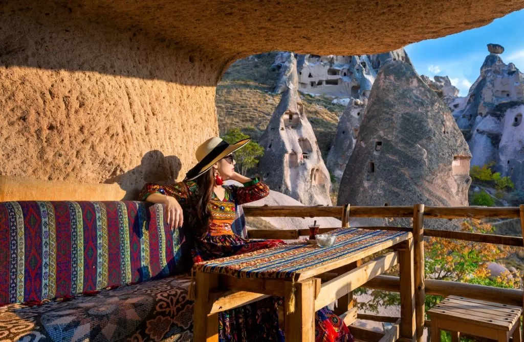A girl seating in a Cave hotel looking outside.