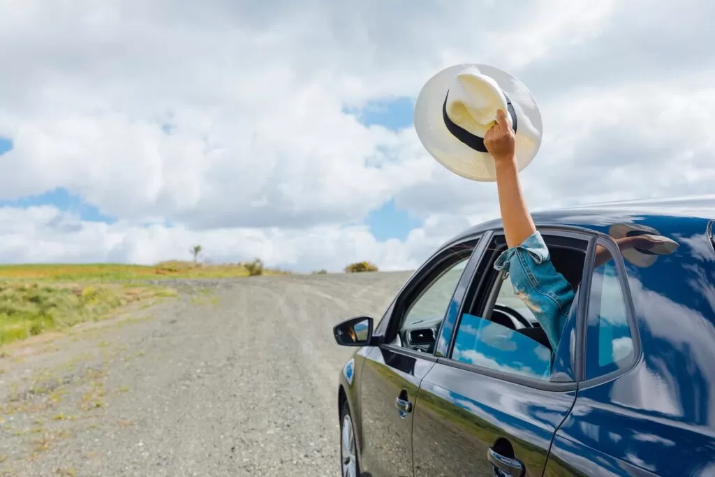 A person wave his hat in the middle of a road trip
